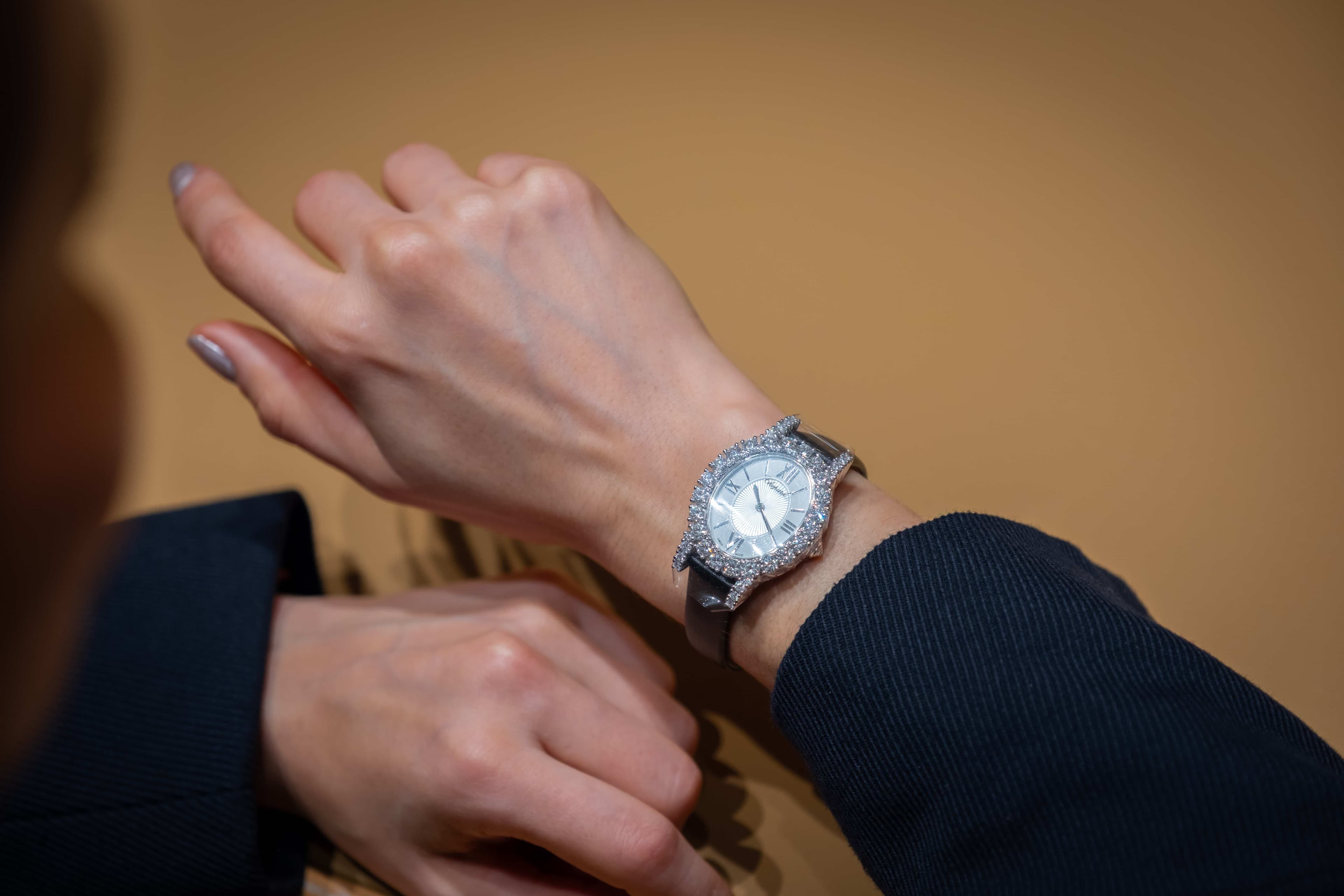 A luxury Chopard L'Heure du Diamant watch with a full diamond bezel and silver dial worn on a woman's wrist.