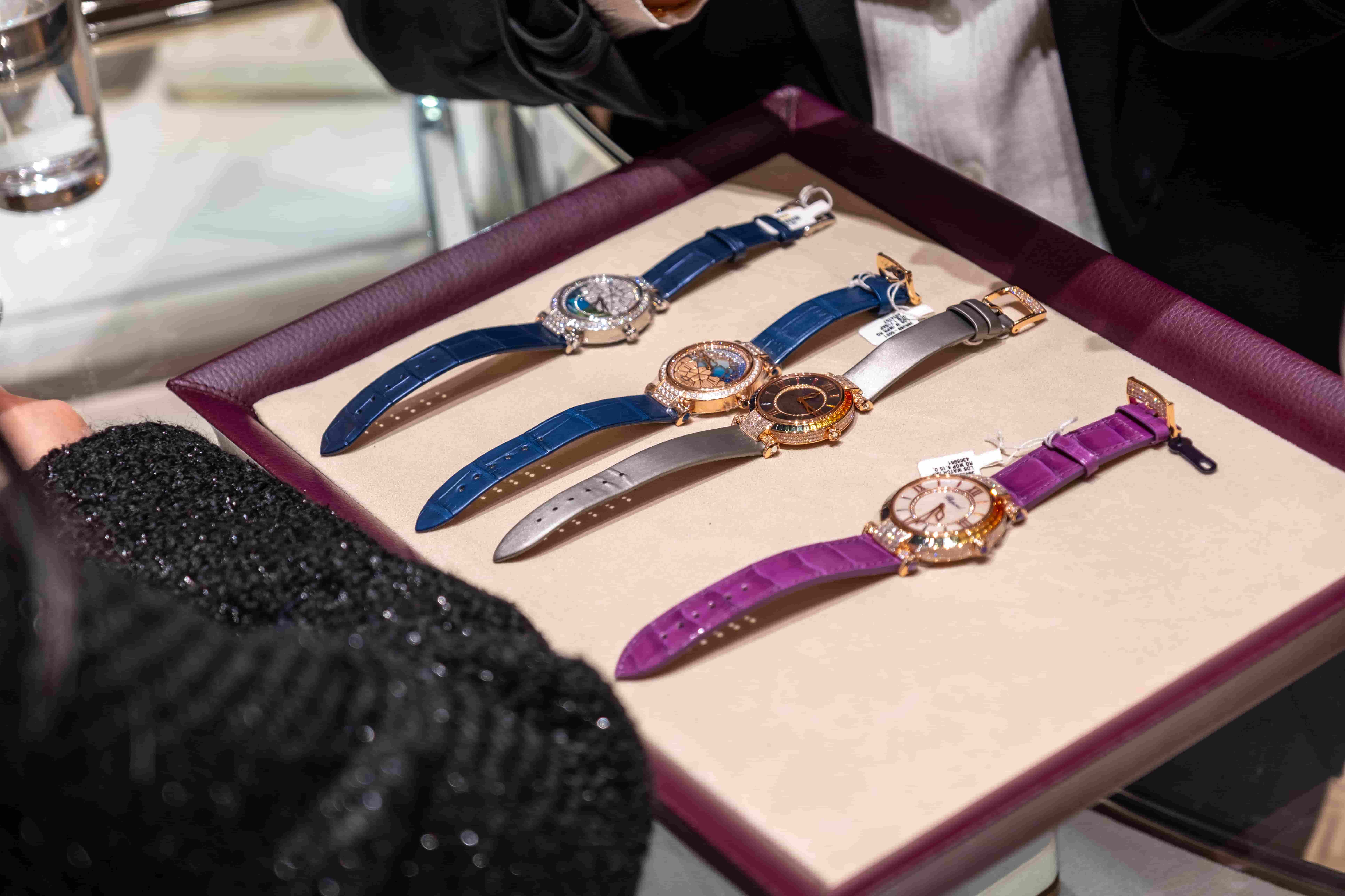 A luxury display tray featuring a collection of Chopard Imperiale watches with colorful leather straps and diamond bezels at an exclusive event.